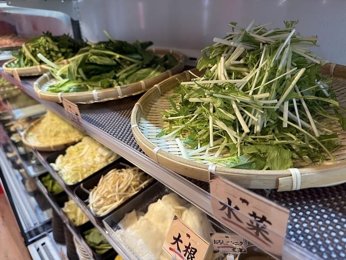 ざるに盛られた水菜など島野菜が並ぶビュッフェコーナー