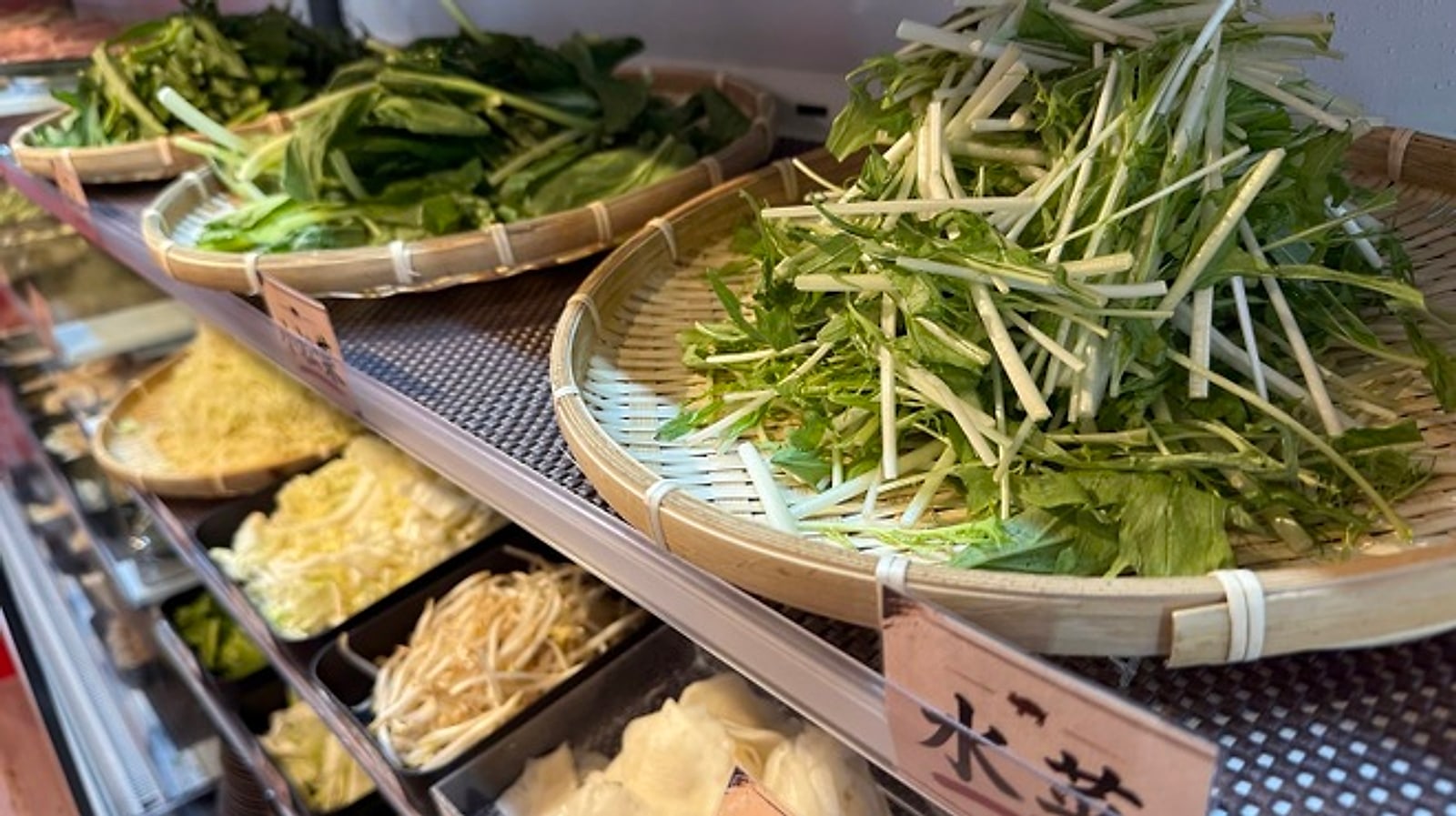 ざるに盛られた水菜など島野菜のビュッフェ